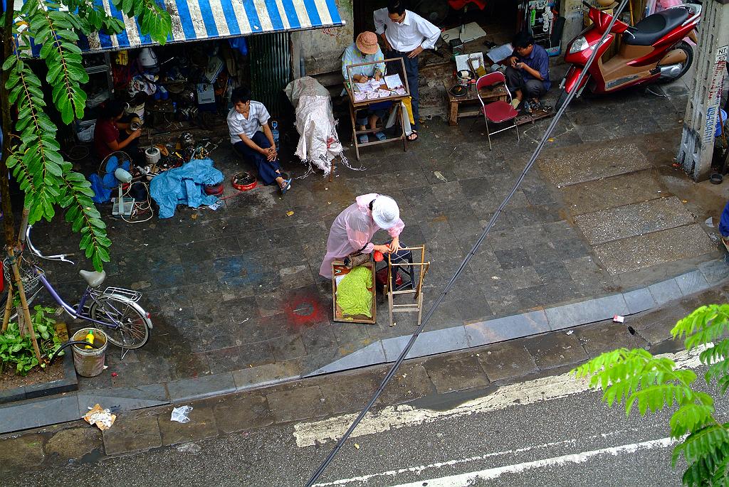 dscf1667.jpg - Eine Straßenverkauferin baut bei Regen ihren Stand auf.